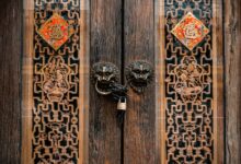 A decorative wooden door with ornate carvings and a padlock, showcasing traditional design.